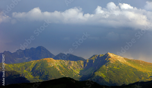 Panoramic view of High Tatra Mountains with Kasprowy Wierch, Czerwone Wierchy and Swinica peaks under clouds seen from Zakopane in Poland