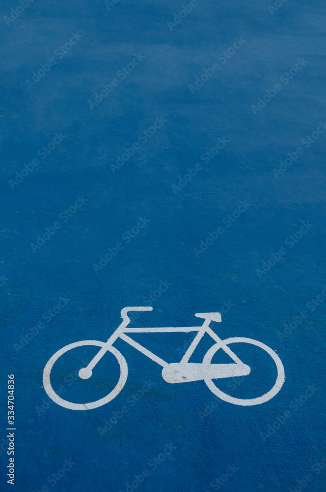 Fototapeta premium road sign of a bicycle painted on the ground on blue background