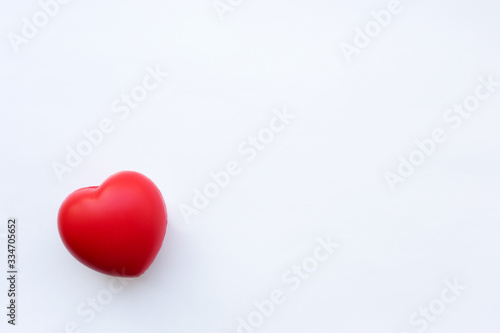 An isolated red heart lies on a white background