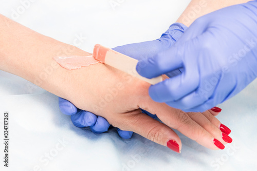 The process of laser depilation of female limbs in the beauty salon. 