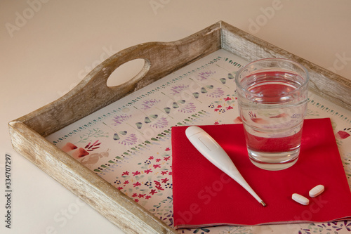 Tray with water glass, pills and thermometer, red and white theme