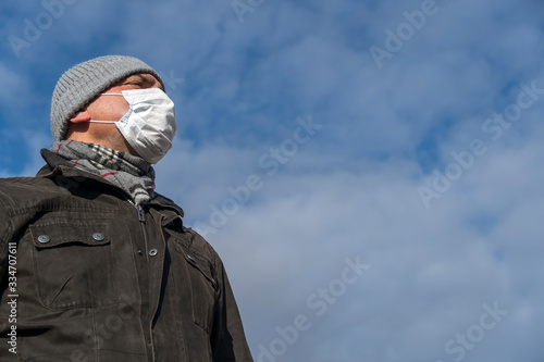 Wallpaper Mural Disease outbreak, coronavirus covid-19 pandemic. Close up portrait from below of a man posing outdoors protecting his face with a mask Torontodigital.ca