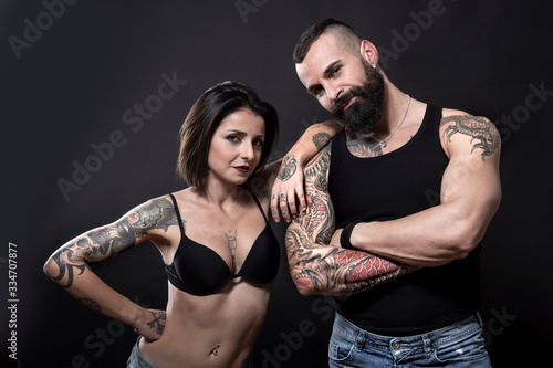Tablou pe pânză coppia di ragazzi tatuati, che mostrano i loro tatuaggi e i loro muscoli, isolat