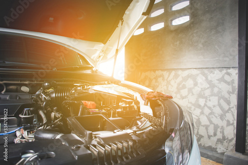 Car open hood in vehicle repair shop for maintenance service by mechanic,sunlight on background. photo