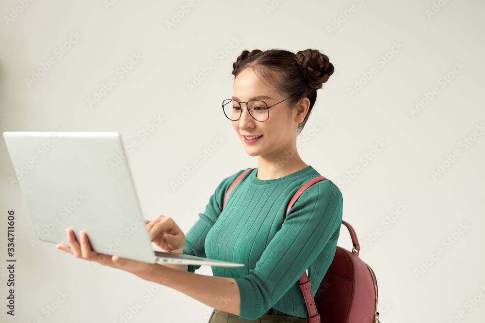 Young happy smiling woman in casual clothes holding laptop and sending email to her best friend Young happy smiling woman in casual clothes holding laptop and sending email to her best friend