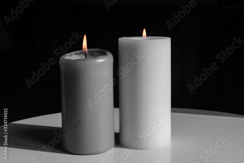 three grey candles on a dark background