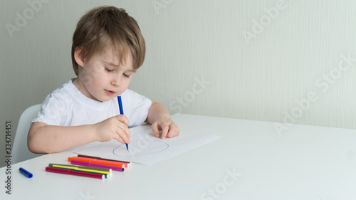 Little boy sitting on the chair and drawing