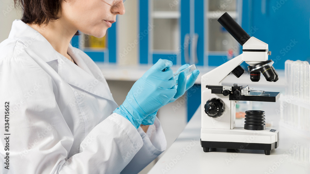 Side view woman using a microscope Side view woman using a microscope