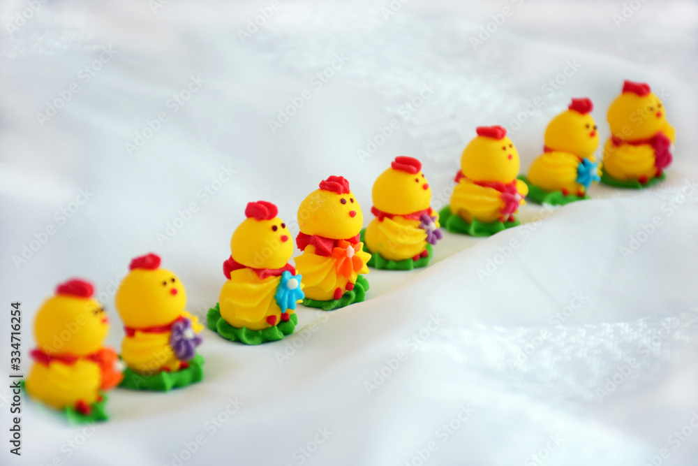 Easter minimalism concept. Decorative bright easter chickens on a white background. Yellow beautiful Easter decor of chickens on selective focus with copy space for text.