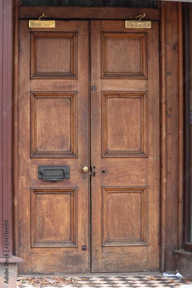 a close up view of a old double wooden door leading into a urban building