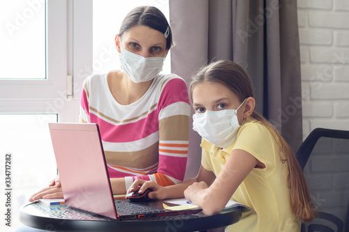 The quarantined family in the isolation ward, mom and daughter doing homework, looked into the frame