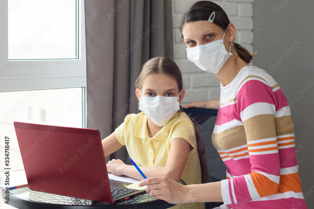 Mom and daughter do their homework in self-isolation mode through online services Mom and daughter do their homework in self-isolation mode through online services
