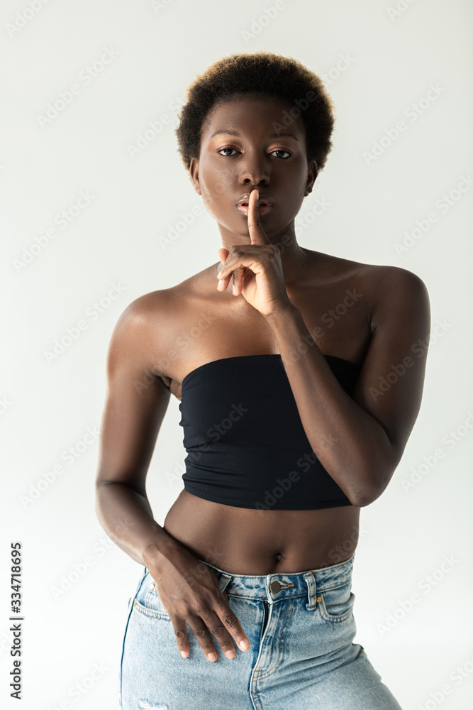 african american girl in jeans and black top showing silence symbol  isolated on grey Stock Photo | Adobe Stock