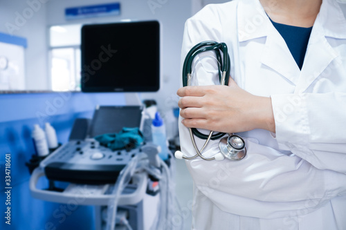 Woman doctor holding stethoscope on hospital background