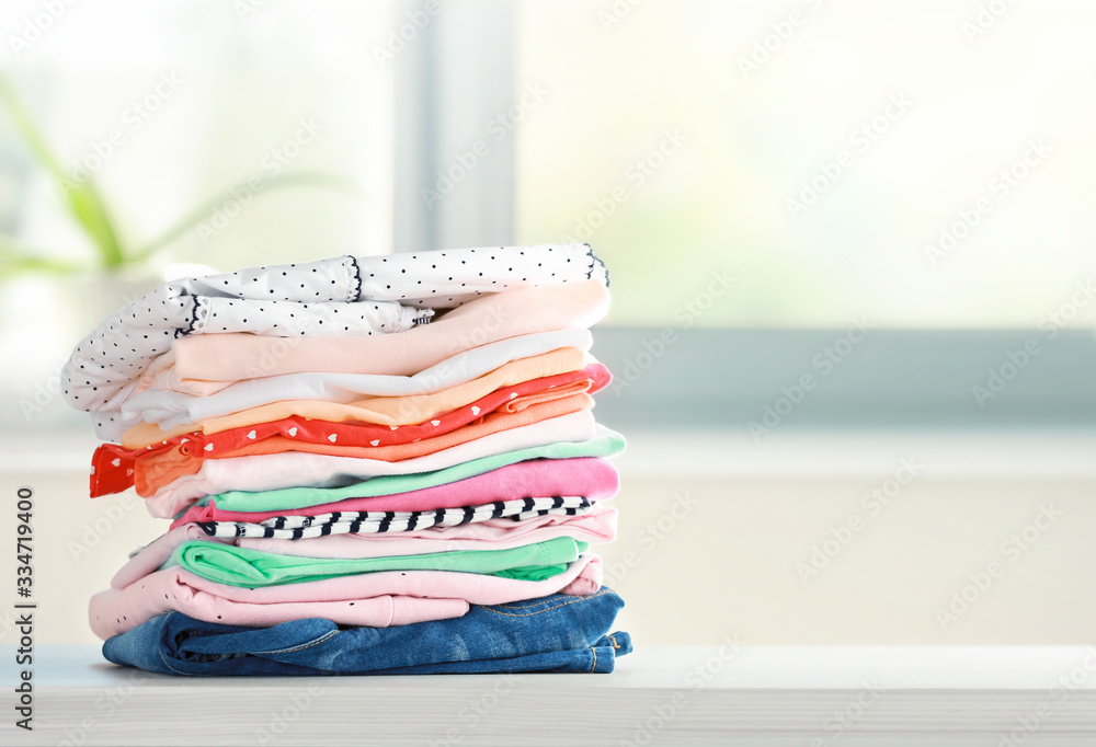 Stack of cotton colorful clothes,folded clothing on table empty space. - obrazy, fototapety, plakaty 