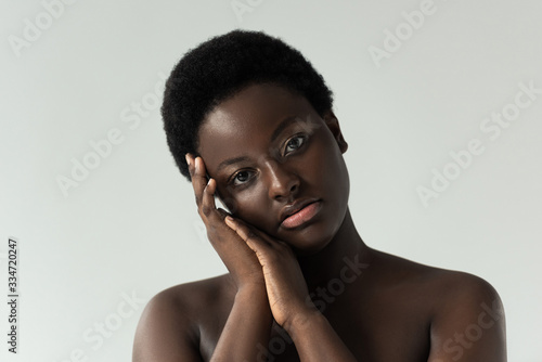 attractive tender nude african american girl touching face isolated on grey