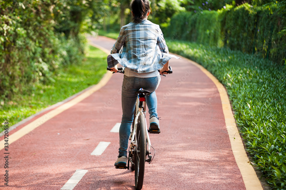 Naklejka premium Woman cyclist riding mountain bike in park