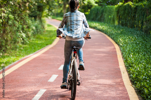 Woman cyclist riding mountain bike in park