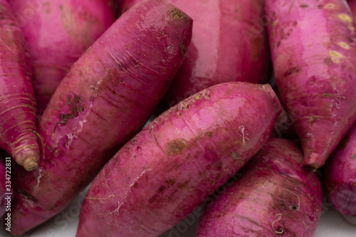 Pile of whole purple daikon radish isolated on white background