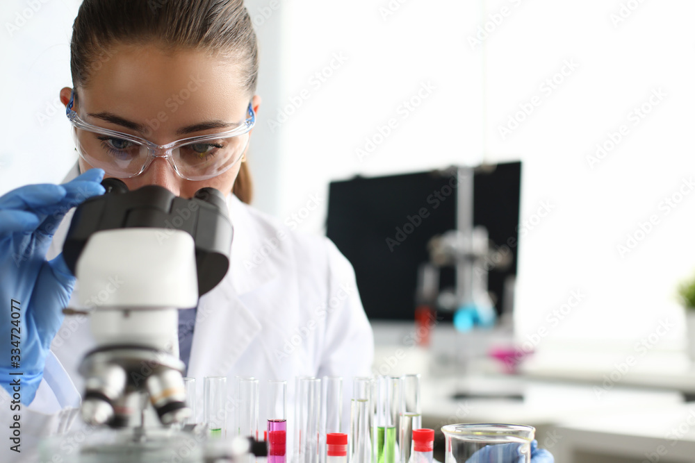 Close-up of scientist using microscope and test tubes. Laboratory assistant making analysing sample of medicines in research lab. Chemical experiments concept Close-up of scientist using microscope and test tubes. Laboratory assistant making analysing sample of medicines in research lab. Chemical experiments concept