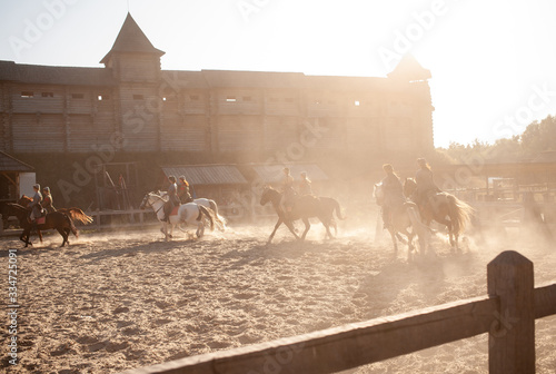 horse riders near the castle at sunset