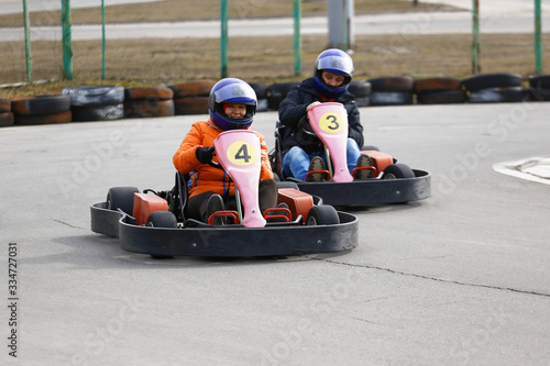 girl is driving Go-kart car with speed in a playground racing track. © makam1969