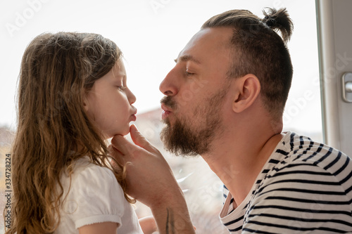 father and little daughter kissing