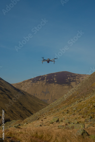 A Small Drone Hovers Above a Remote Valley in Scotland