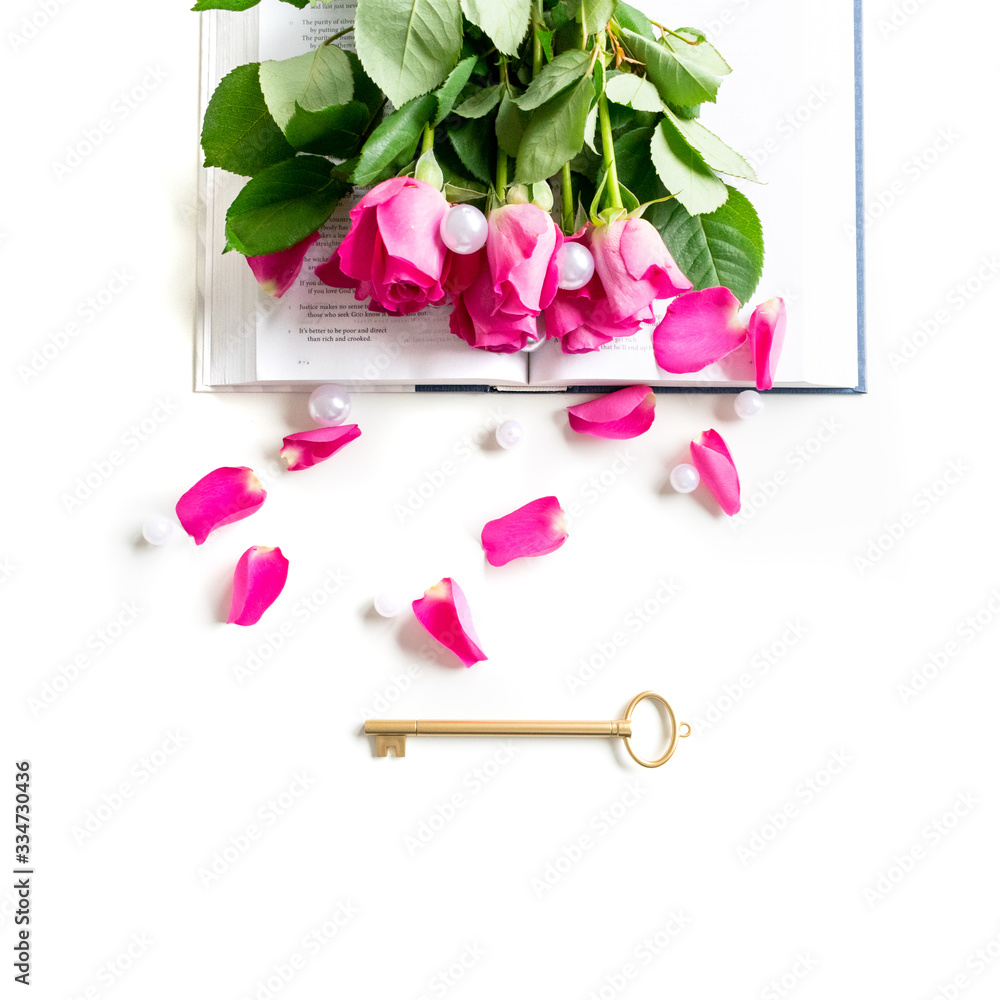 Lifestyle flat lay: White pearls, pink roses, petals, golden key and open book on clean white background. Mock-up. Copy space. Lifestyle flat lay: White pearls, pink roses, petals, golden key and open book on clean white background. Mock-up. Copy space.