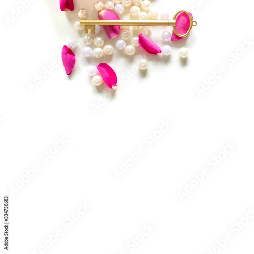 Pink Bible flat lay: Pearls, pink rose petals, open book and golden key on white bright background. Morning devotional with pink roses. Top view. Baselland, Switzerland - 22.11.2019 © Madeleine