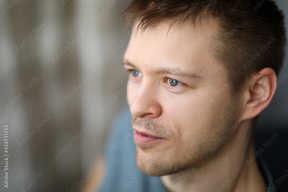 Obraz premium Close-up portrait in profile of an ordinary guy. Appearance young man. Man looks into distance. Calm and satisfaction with life. Positive emotions from loneliness during self-isolation