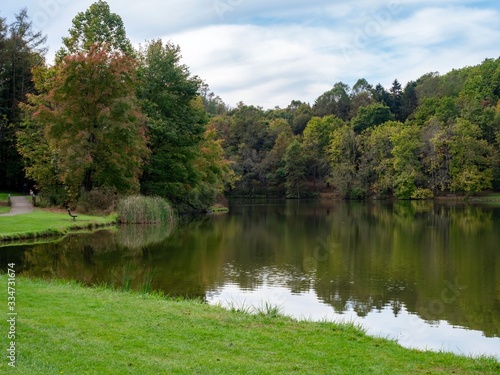 Twin Lakes in the Laurel Highlands of Pennsylvania with the tree line reflecting in the water  grass foreground and blue sky with clouds in the background.  Beautiful scenic nature landscape.