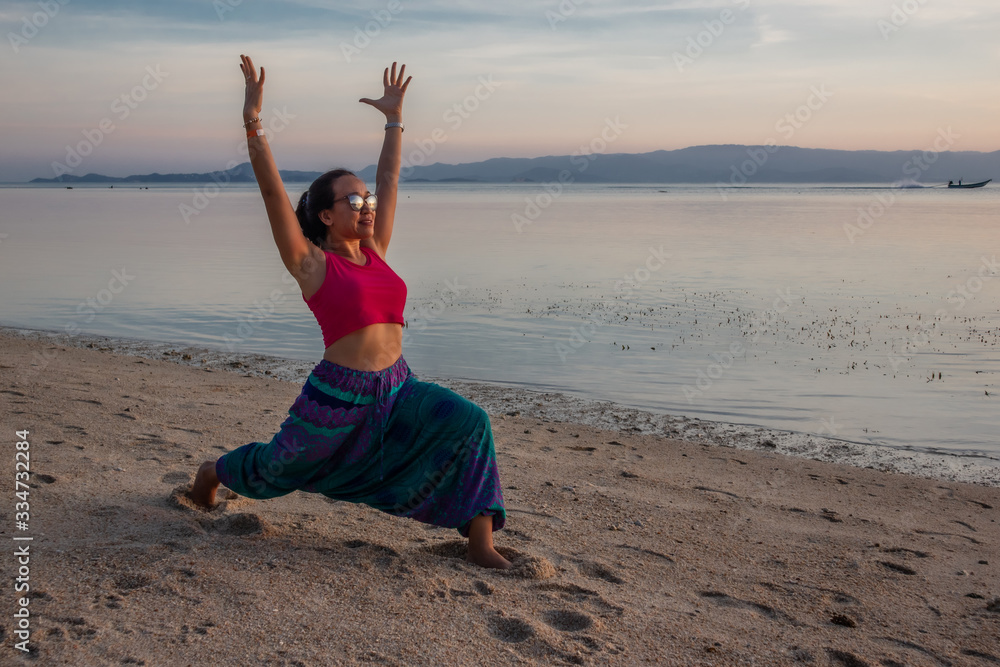 Asian Thai woman practicing yoga in Haad Seekantang beach, Koh Phangan island, Thailand Asian Thai woman practicing yoga in Haad Seekantang beach, Koh Phangan island, Thailand