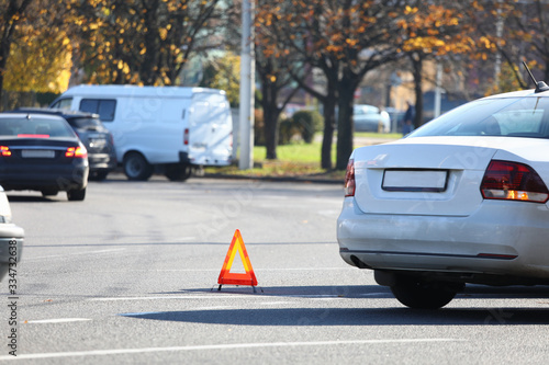 There is yellow triangle accident sign on road. Turn on emergency light and set emergency parking sign. Call insurance commissioner and paperwork. Attraction lawyer. Make diagram an accident