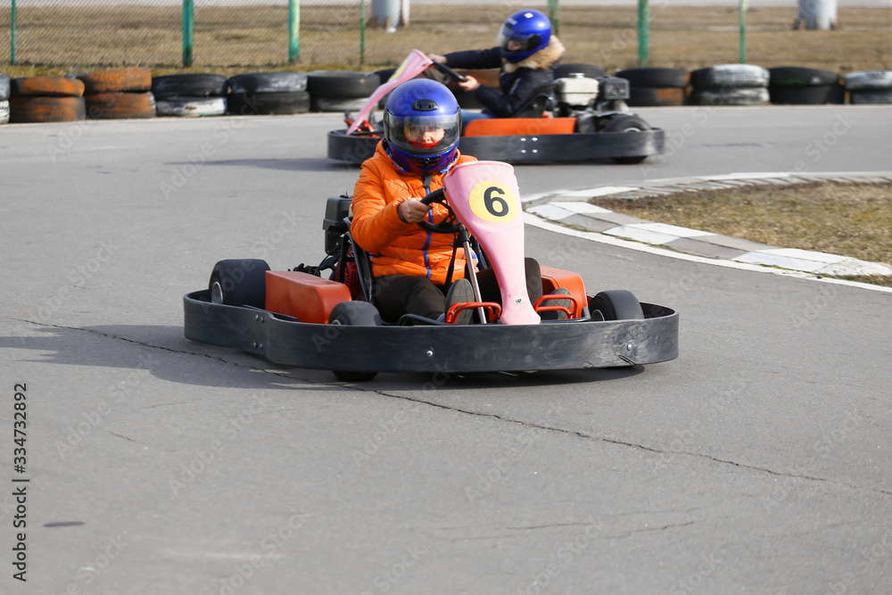 Fototapeta premium girl is driving Go-kart car with speed in a playground racing track.