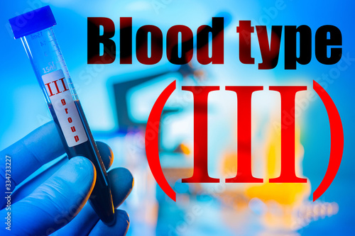 Inscription is the third blood type. Gloved hand holds a test tube with blood. Logo 3 group. Concept - blood transfusion station. Concept - search for a donor for transfusion. Medic holds a test tube photo