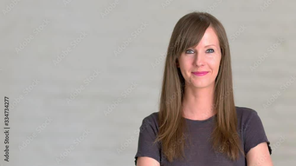 Happy young woman in her 30s looking at the camera, smiling. Longer 4K UHD video clip. Happy young woman in her 30s looking at the camera, smiling. Longer 4K UHD video clip.
