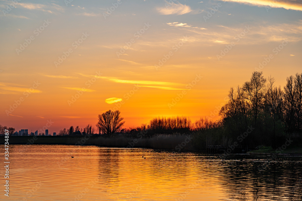 The sun has just gone down behind the trees along the lake Zoetermeerse Plas, Zoetermeer, Netherlands. The sun has just gone down behind the trees along the lake Zoetermeerse Plas, Zoetermeer, Netherlands.