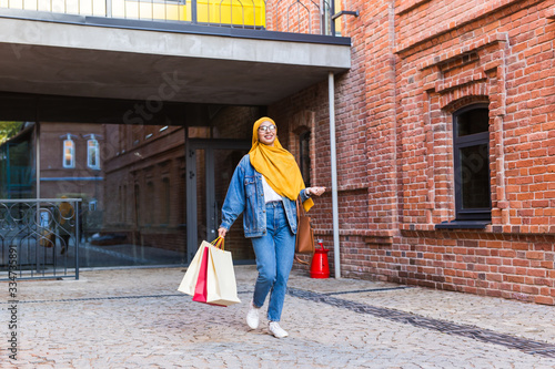 Sale and buying concept - Happy arab muslim girl with shopping bags after mall © satura_