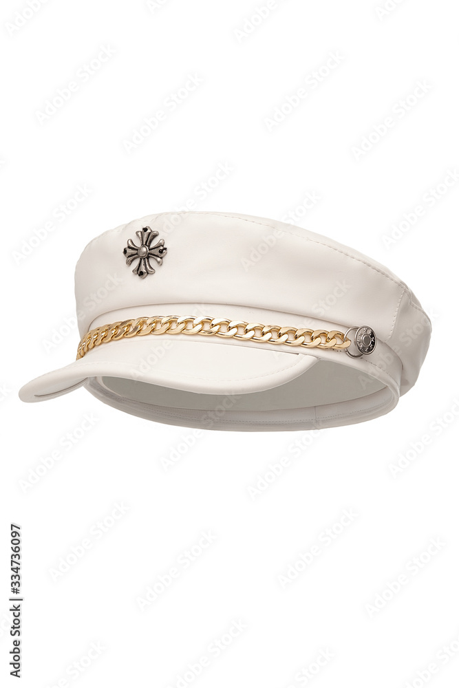Subject shot of a white leather peak cap with a golden chain under the visor and a metal stylized cross on the crown. The stylish headwear is isolated on the white background. Subject shot of a white leather peak cap with a golden chain under the visor and a metal stylized cross on the crown. The stylish headwear is isolated on the white background.