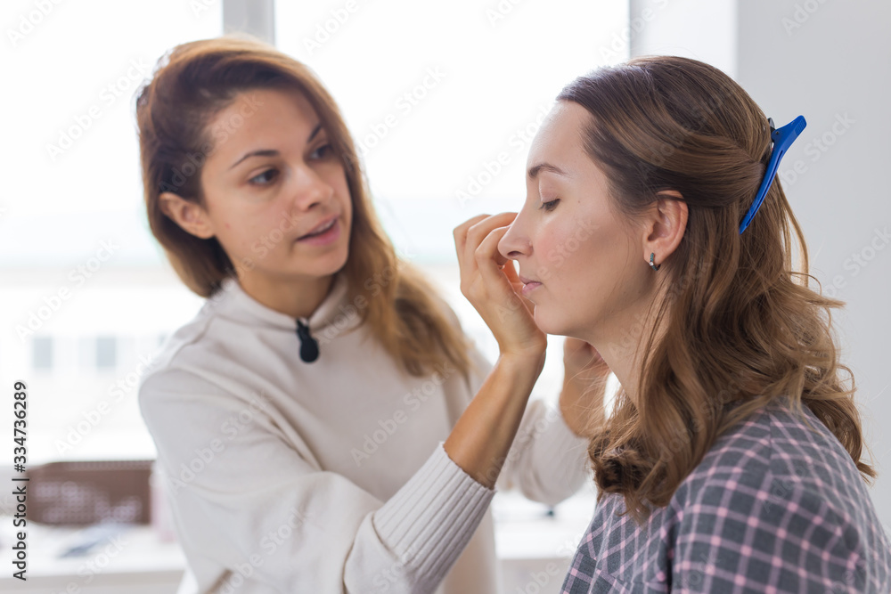 Beauty and cosmetics concept - Makeup artist doing professional make up of young woman Beauty and cosmetics concept - Makeup artist doing professional make up of young woman
