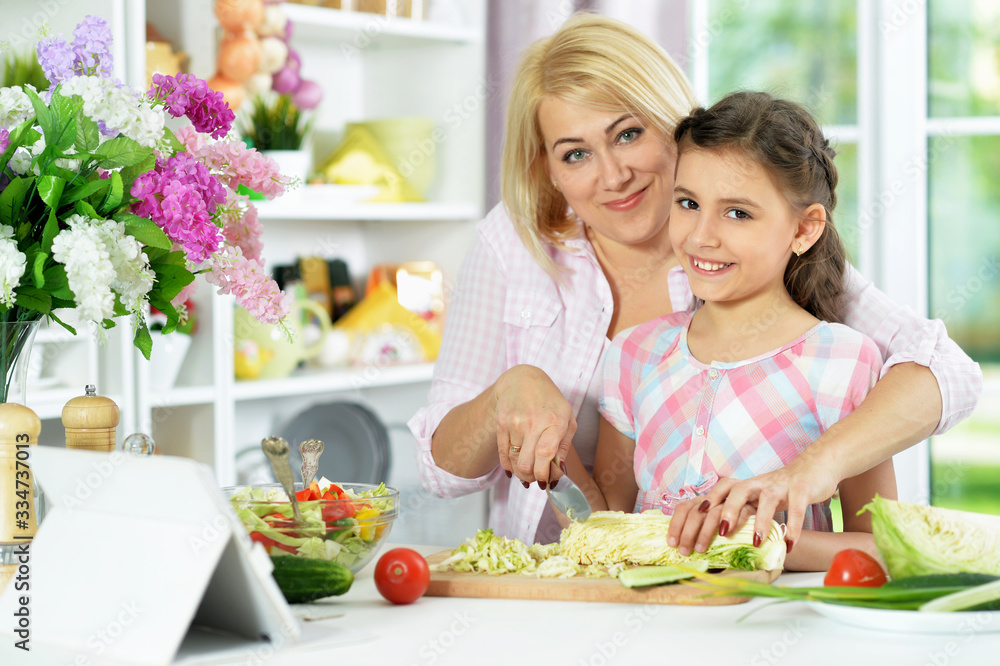 Cute little girl with her mother cooking together Cute little girl with her mother cooking together