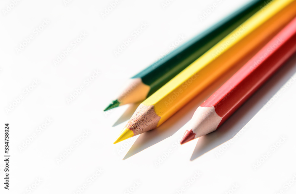 Three color pencils - red, yellow, green on a white background. Concept - school, education, art education Three color pencils - red, yellow, green on a white background. Concept - school, education, art education