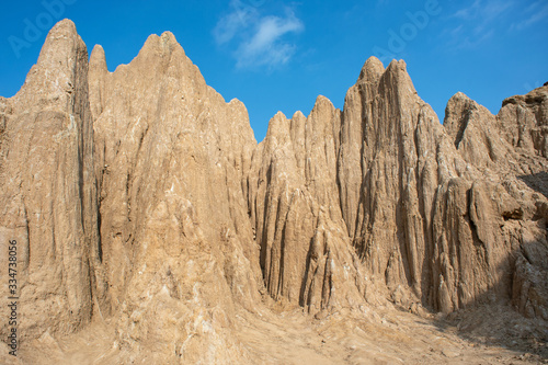 Orange earth sticks and small trees against the blue sky