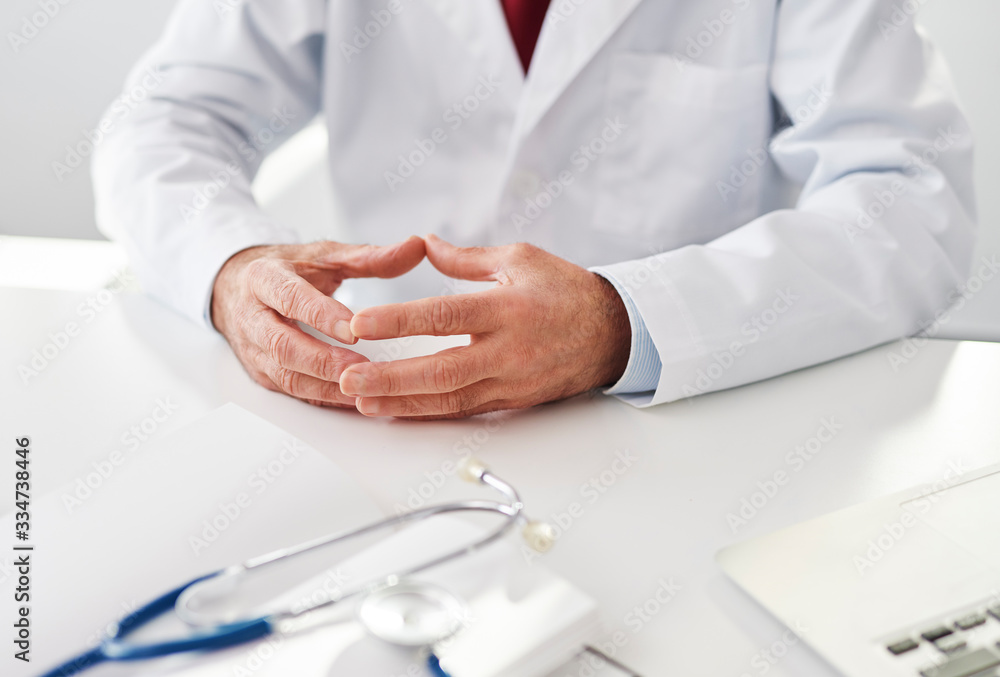 Close up of a doctor sitting at a desk Close up of a doctor sitting at a desk