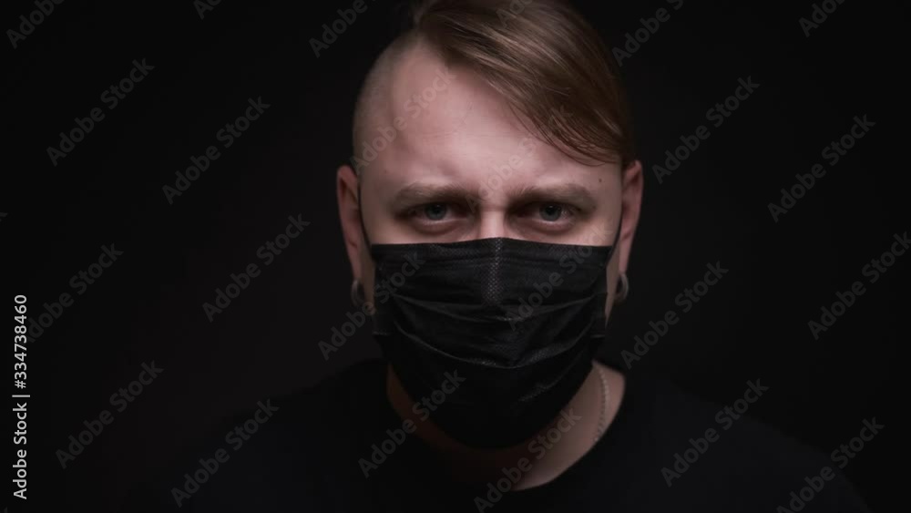 Caucasian man time lapse black medical mask,looking at camera and coughing, portrait on black background, ill in quarantine,self-isolation,close-up,health and medical concept Caucasian man time lapse black medical mask,looking at camera and coughing, portrait on black background, ill in quarantine,self-isolation,close-up,health and medical concept