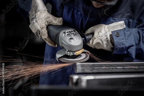 Close up on a man hold an angle grinder with sparks