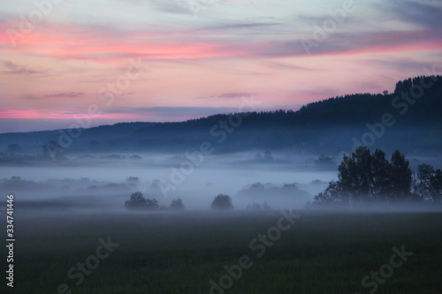 morning sunrise with fog in an open field