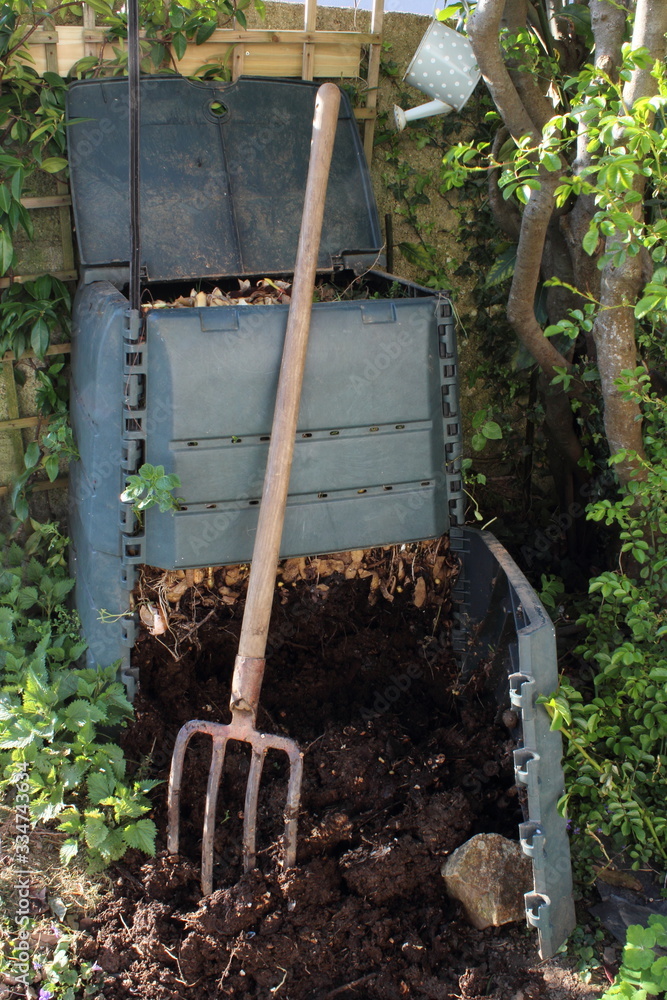 Compost bin and pitchfork in the garden. Organics recycling. Zero waste. Compost bin and pitchfork in the garden. Organics recycling. Zero waste.