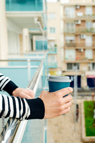 young man having a coffee in the balcony photo